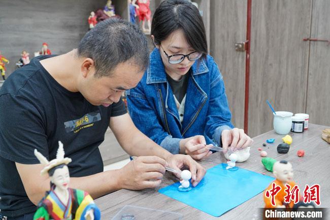 <a target='_blank'  data-cke-saved- >中新社</a>記者(右)現(xiàn)場體驗面塑制作過程。　陳爭強(qiáng) 攝