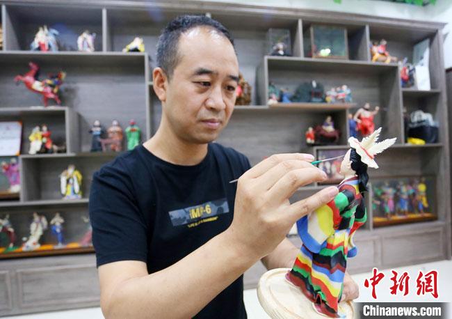 圖為安秋平正在創(chuàng)作代表隴南文縣民俗的《白馬人》作品?！「哒?攝