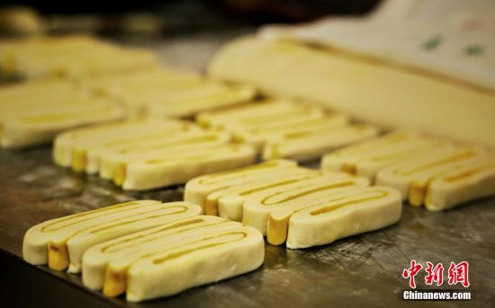 圖為面劑被涂上胡麻油，切成條狀用作月餅的花型制作。張文 攝