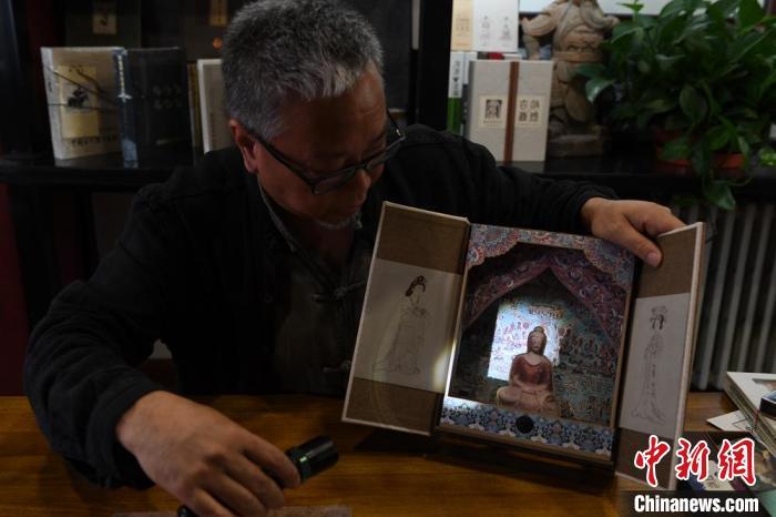 圖為讀者出版集團讀者晉林工作室獨立出品人徐晉林，展示互動性強的敦煌題材手工書。(資料圖) 楊艷敏 攝