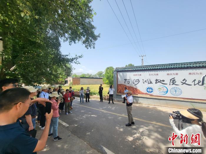 圖為中國地質(zhì)大學(xué)(北京)教授張緒教介紹村落情況?！『衍?攝