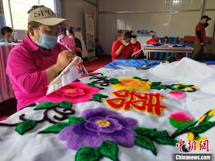 圖為婦女制作青繡?！?zhí)砀?攝