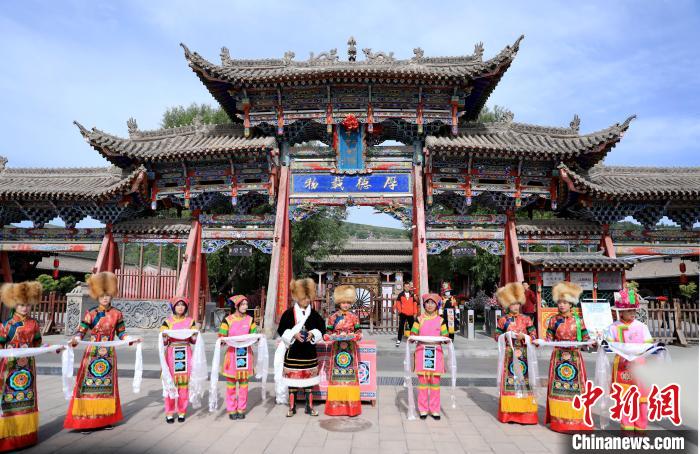 圖為身穿土族服飾的工作人員迎接訪客?！⊙Φ?攝