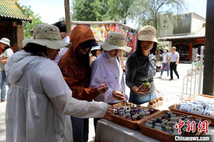 圖為民眾挑選手工藝產(chǎn)品?！⊙Φ?攝