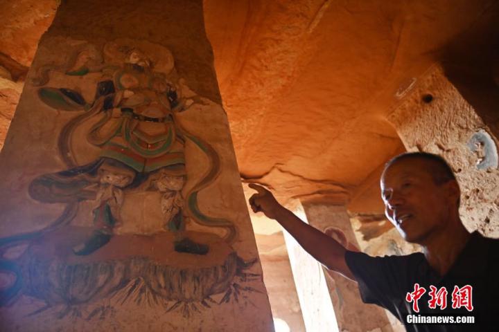 7月15日，甘肅省平?jīng)鍪袥艽h百里石窟長廊羅漢洞石窟內(nèi)，該窟文保員郭建平介紹窟內(nèi)石刻彩繪壁畫。郭建平家中三代人曾自發(fā)保護羅漢洞石窟。羅漢洞石窟遺存40余個窟龕，以北魏至清代風(fēng)格為主。中新社記者 李亞龍 攝</p>
<p>