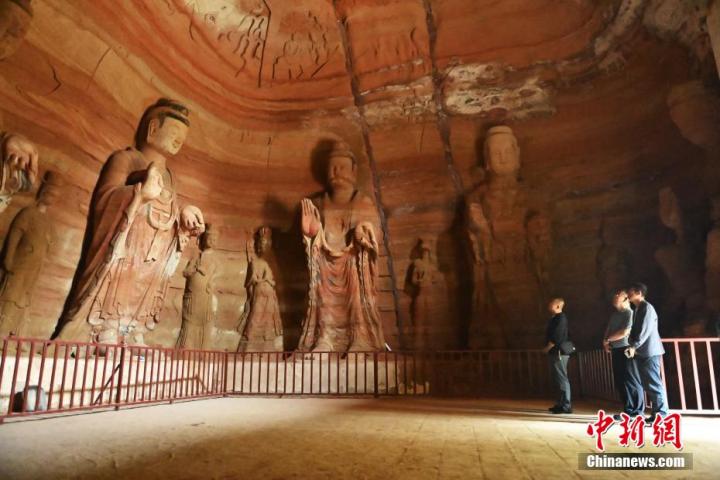 7月15日，游人參觀甘肅省平?jīng)鍪袥艽h百里石窟長廊中的南石窟寺1號窟。百里石窟長廊位于涇川縣境內(nèi)，由512個石窟、5眼窟中石井組成，現(xiàn)存王母宮石窟、鳳凰山石窟、南石窟寺、丈八寺石窟、羅漢洞石窟、太山寺石窟等規(guī)模較大的石窟群，還有數(shù)量眾多的小石窟群。南石窟寺開鑿于北魏永平三年，其中1號窟屬于大型七佛窟，七佛高達6米。中新社記者 李亞龍 攝