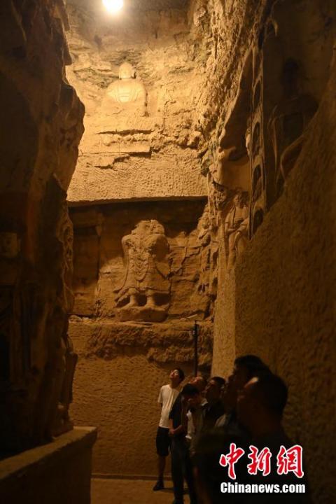 7月15日，游人參觀甘肅省平?jīng)鍪袥艽h百里石窟長廊中的王母宮石窟。百里石窟長廊位于涇川縣境內(nèi)，由512個石窟、5眼窟中石井組成，現(xiàn)存王母宮石窟、鳳凰山石窟、南石窟寺、丈八寺石窟、羅漢洞石窟、太山寺石窟等規(guī)模較大的石窟群，還有數(shù)量眾多的小石窟群。王母宮石窟又名千佛洞，該窟設(shè)計宏大，造像生動，窟內(nèi)擁有造像數(shù)百尊，是較為珍貴的佛教文化遺存。中新社記者 李亞龍 攝</p>
<p>